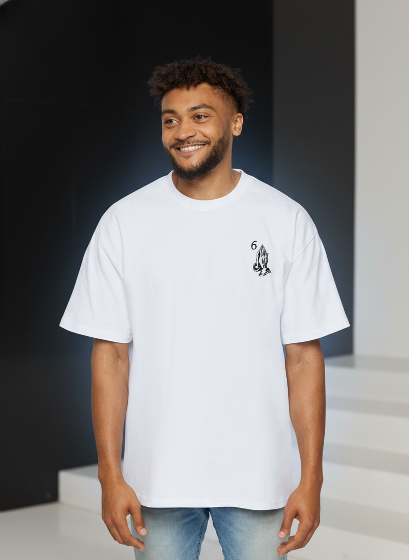 Diverse model wearing a black oversized tee with 'Blessed' graphic, in an elegant, monochromatic setting with subtle blue tou